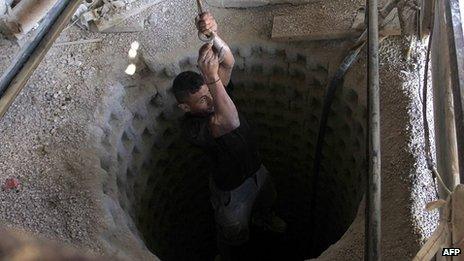 A Palestinian worker is lowered into a smuggling tunnel under the border with Egypt (file photo)