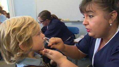 Nurse giving nasal spray to a school pupil