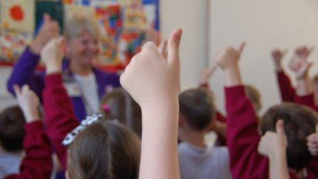 Primary pupils give thumbs up in classroom