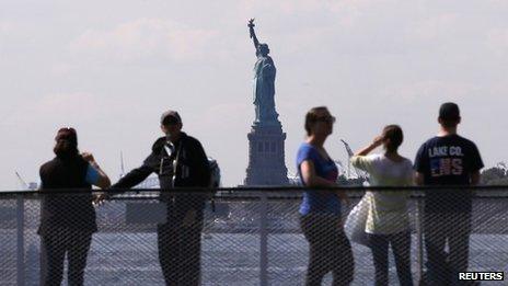 Tourists pause to view the Statue of Liberty from the deck of a Liberty Island ferry boat at Battery Park in New York in this file photo taken 30 September