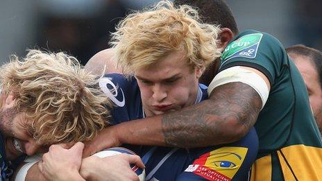 Castres' Scottish lock Richie Gray is tackle by Northampton's Courtney Lawes