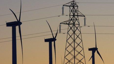 Wind turbines next to electricity pylons