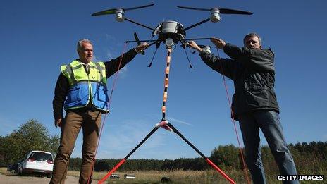 Men holding drones in the air