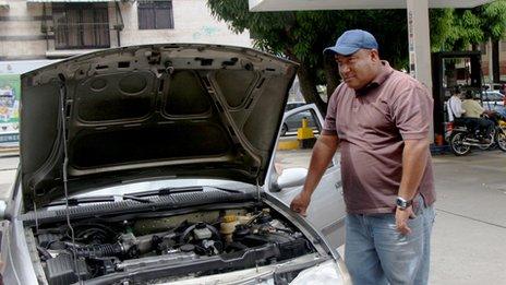 Daniel stands next to his car in Caracas, Venezuela in September 2013