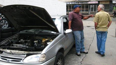 Daniel (left) stands next to his car at a petrol station in Caracas, Venezuela in September 2013