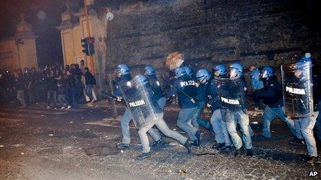 Policemen in riot gear chase after protesters outside the Society of St. Pius X headquarters, a schismatic Catholic group, where the funeral of former Nazi war-criminal Erich Priebke was scheduled to take place in Albano Laziale, in the outskirts of Rome, Tuesday, Oct. 15, 2013