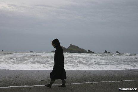 Woman walking along shore