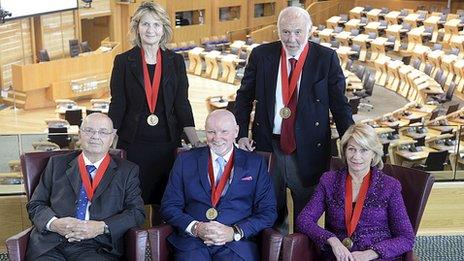 Five of the six winners of the Carnegie Medal of Philanthropy 2013 are pictured in the debating chamber of the Scottish Parliament (Back Row: Dame Janet Wolfson de Botton, Dr. James Simons; Front row: Dr Dmitry Zimin, Sir Tom Hunter and Dr Marilyn Simons)