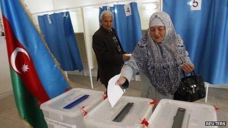 A woman casts her vote during the presidential elections at the polling station in the village of Nardaran