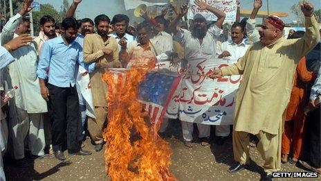 Protestors in Pakistan with a burning US flag