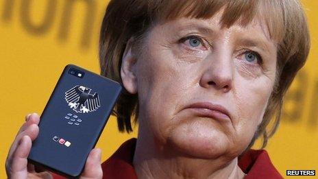 The German Chancellor, Angela Merkel holds a Smartphone