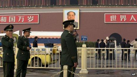 Paramilitary police officers, police officers, and cleaners work in front of Tiananmen Gate following a car crash in Beijing, China, 28 October 2013