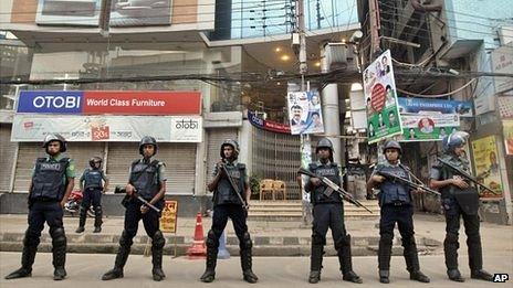 Bangladeshi police officials stand guard on a street during a general strike in Dhaka