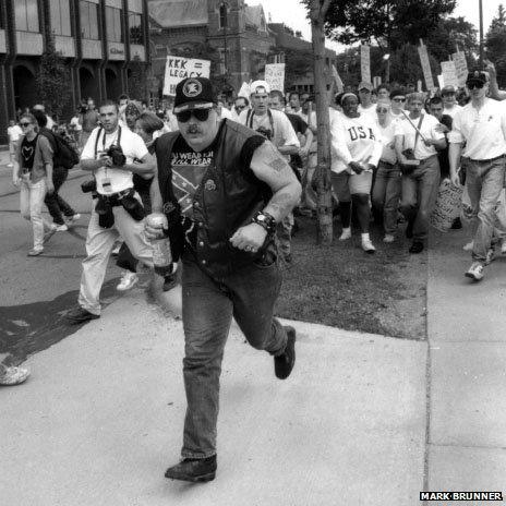 Man being chased by anti-KKK demonstrators