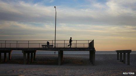 A jogger runs to the end of a boardwalk damaged by Hurricane Sandy in October 2012 in the borough of Queens in New York October 28, 2013