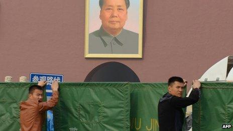 Plainclothes police hold barriers to shield the scene of a car crash in front of the iconic portrait of Mao Zedong at Tiananmen Gate in Beijing, China, on 28 October 2013