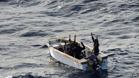 The six Somali pirates in a small motor boat surrender