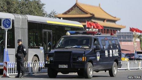 A policeman stands guard next to a special police vehicle near Tiananmen Gate, in Beijing, 29 October 2013