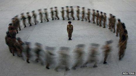 Commander watches paramilitary police recruits run in a circle during training, Xinjiang (file photo - 28 August)