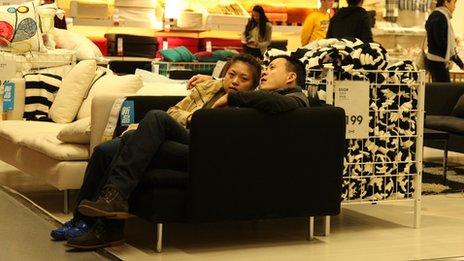 A couple sit on a sofa in Ikea