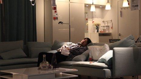 A man sleeps on a sofa in Ikea