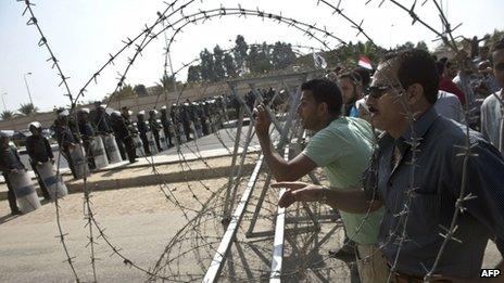 Supporters of the Muslim Brotherhood and of ousted president Mohamed Morsi face riot police as rally outside the Police Academy where his trial is taking place on November 4, 2013, in Cairo