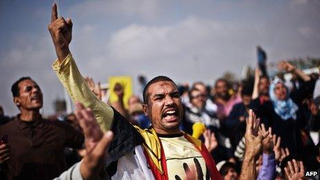 Supporters of ousted President Mohammed Morsi shout slogans in his support outside the Police Academy where his trial is taking place on November 4