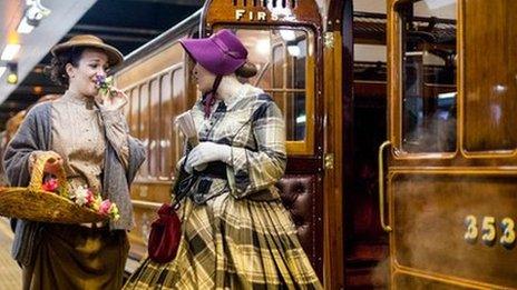 Women in heritage costumes next to the carriage