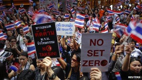 People wave flags and hold placards as thousands protest against the amnesty bill in Bangkok's central business district, Thailand, 6 November 2013