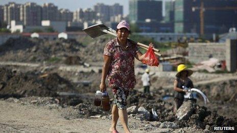 A female migrant construction worker walks towards her dormitory after a shift at a residential construction site in Shanghai on 6 August 2013