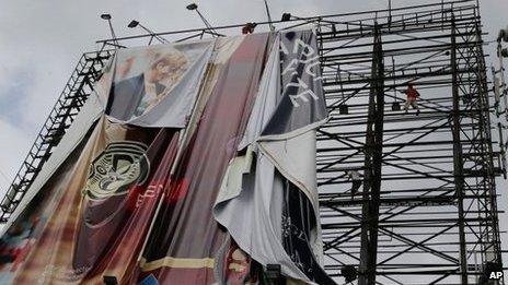 Filipino workers bring down a giant billboard along a busy highway as they prepare for Typhoon Haiyan in suburban Makati, south of Manila, Philippines, 7 Nov 2013