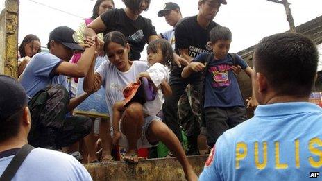 Residents living near the slopes of Mayon volcano are evacuated to public schools by police in anticipation of the powerful typhoon Haiyan, 7 November