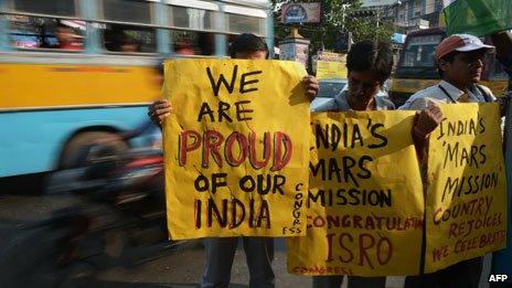 People hold placards in support of the Mars mission