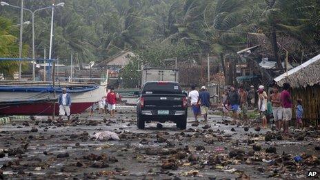 Debris litters the road by a coastal village in Legazpi in the Philippines