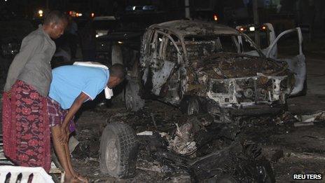 Residents look at the scene of an explosion outside the Maka Al-Mukarama hotel in Somalia's capital Mogadishu (8 November 2013)