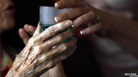 Nurse gives elderly woman a drink