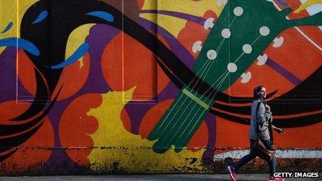 Woman walks past street art in Dublin