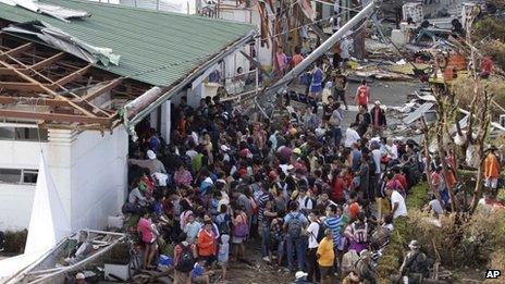 Residents queue up to receive relief supplies and medicine at Tacloban airport on 11 November