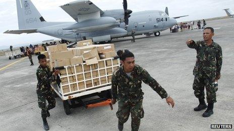 Military personnel deliver aid at the destroyed airport in Tacloban