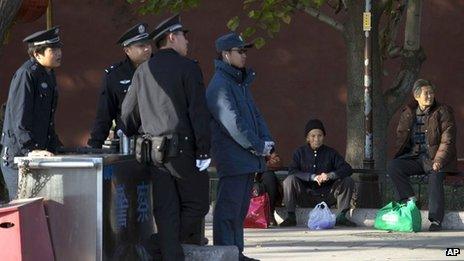 Elderly Chinese women sit on the sidewalk near a security checkpoint set up as part of the increased security during a weekend gathering of the Communist Party's 205-member Central Committee for its third annual plenum in Beijing Tuesday, Nov 12, 2013.