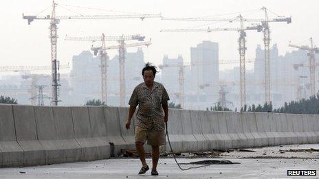 A worker carries a rope at a construction site for a new road in Beijing on 1 August 2013