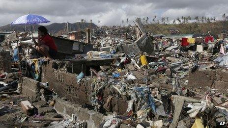 A survivor sits among debris in Tacloban, Leyte province