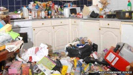 The kitchen in Amanda Hutton's house, with rubbish on the floor and several drink bottles