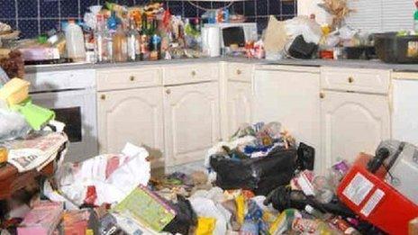 The kitchen in Amanda Hutton's house, with rubbish on the floor and several drink bottles