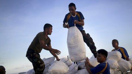 Soldiers moving bags of food aid at an airport in the Philippines