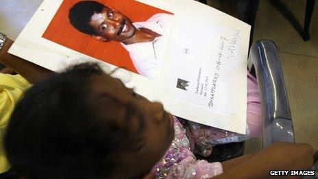 A Tamil girl holds up a photograph of her father who disappeared during the Sri Lankan civil war