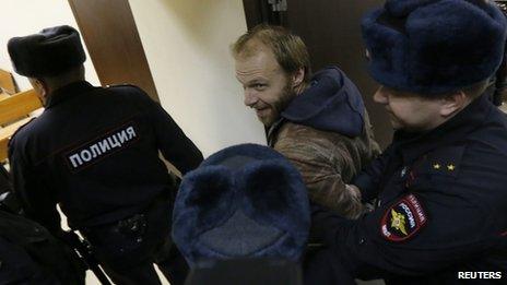 Photographer Denis Sinyakov (C) of Russia, one of the 30 people who were arrested over a Greenpeace protest at the Prirazlomnaya oil rig, is escorted before a court session in St. Petersburg, November 18, 2013