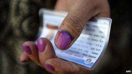 A Nepalese woman shows her finger after election officials marked it with indelible ink at a polling station in Kathmandu on 19 November 2013