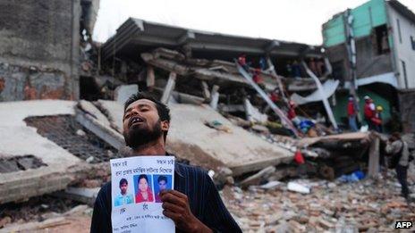 A Bangladeshi man holding photos of his missing relatives after Dhaka's garment factory collapse. Photo: April 2013