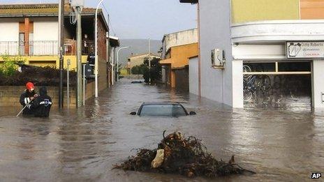 Rescuers work on a flooded street in the town of Uras, Sardinia. Photo: 18 November 2013